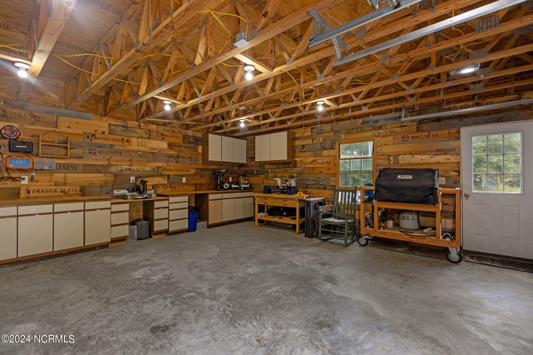 4077 Range Road Stem, NC 27581 - Photo 58 of 67 Interior of detached 3-car garage, currently used as a woodworking shop. Custom wood paneling in garage is repurposed glass shipping crates from a local mom & pop glass shop in Durham.