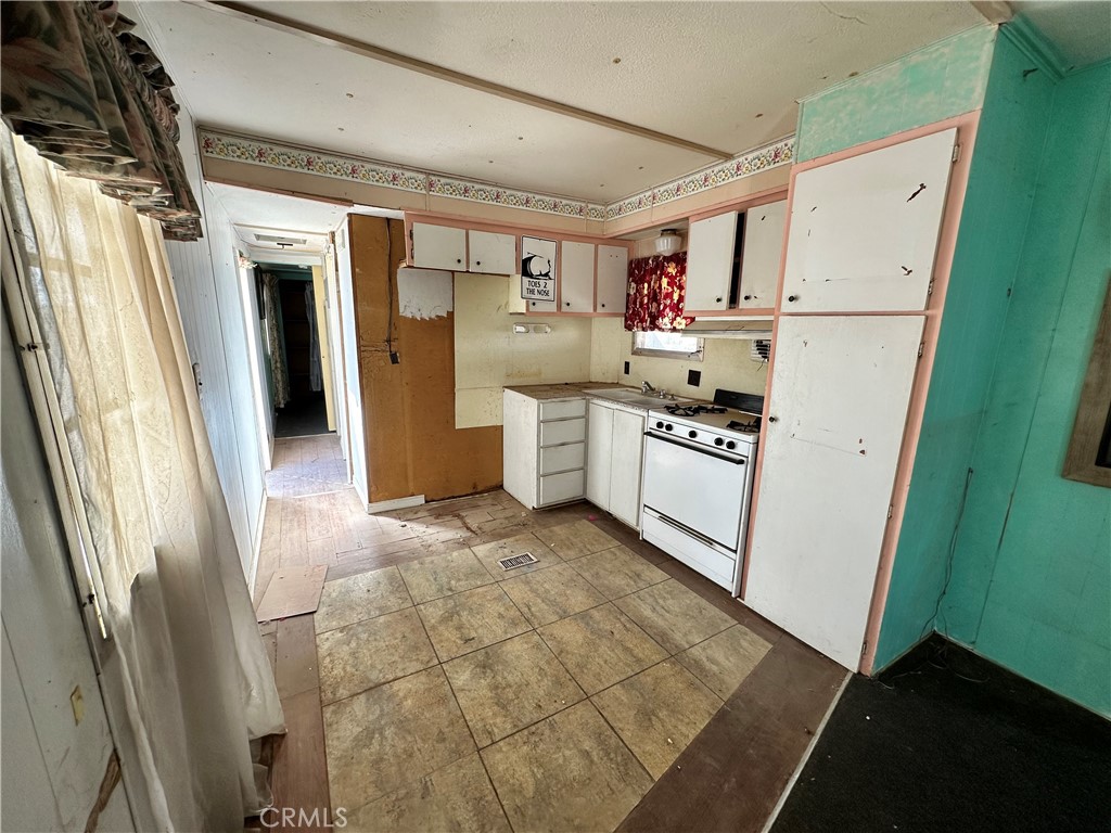 1609 Riviera Drive Blythe, CA 92225 - Photo 18 of 40 a kitchen with a refrigerator a stove top oven and cabinets