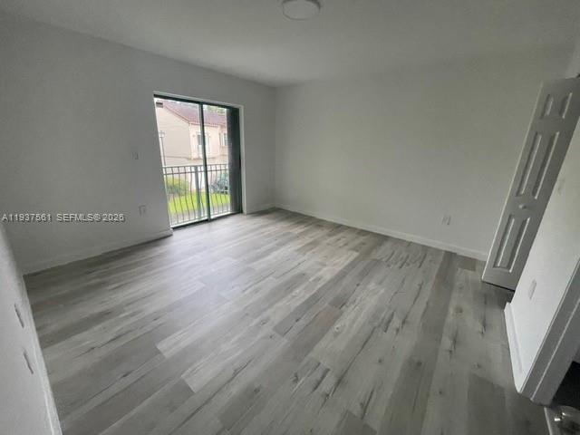 11490 Southwest 148th Court Miami, FL 33196 - Photo 12 of 21 wooden floor in an empty room with a window
