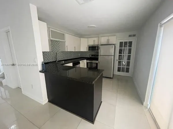 a kitchen with stainless steel appliances granite countertop a refrigerator and a stove