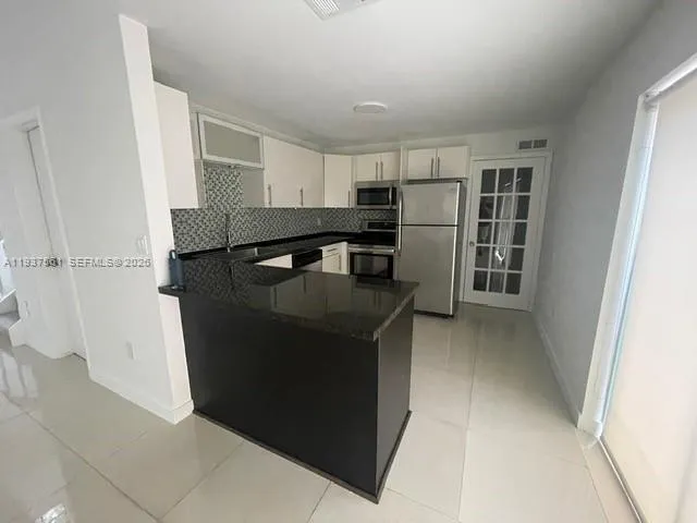 a kitchen with stainless steel appliances granite countertop a refrigerator and a stove