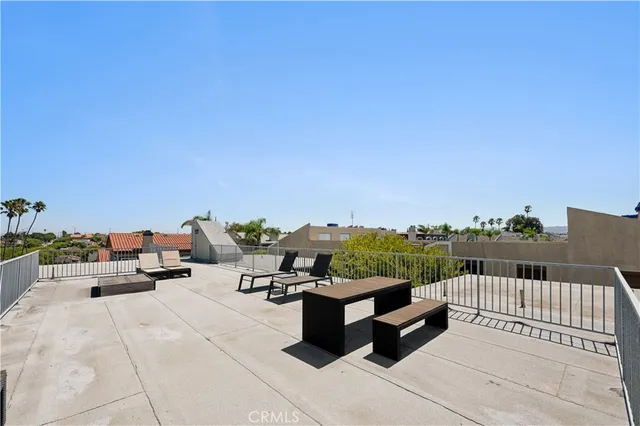 a view of roof deck with couches and city view