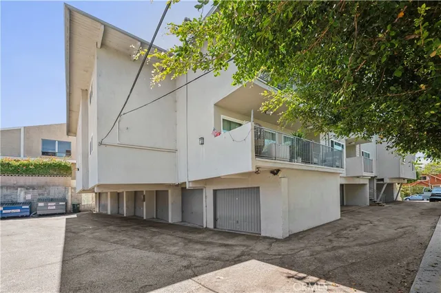 a view of a white house with a large windows and a small yard