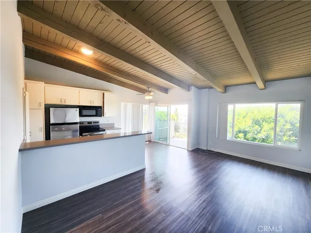 a large kitchen with stainless steel appliances granite countertop a stove a sink and a large window