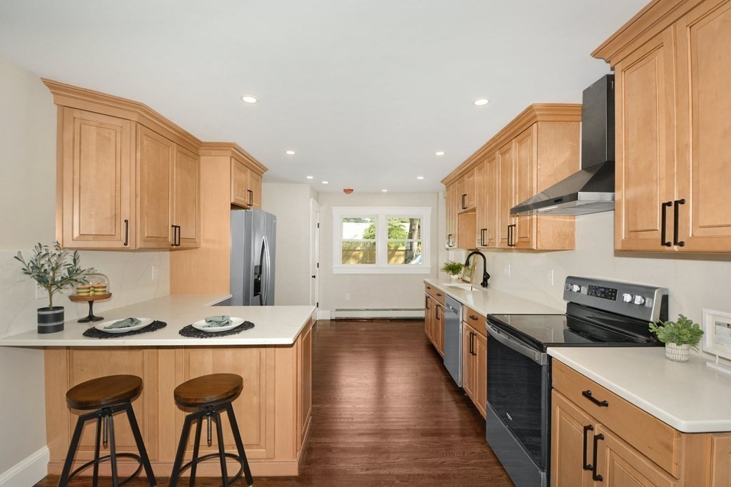 533 Edgell Road Framingham, MA 01701 - Photo 15 of 36 a kitchen with stainless steel appliances granite countertop a refrigerator a sink dishwasher a stove and white countertops with wooden floor