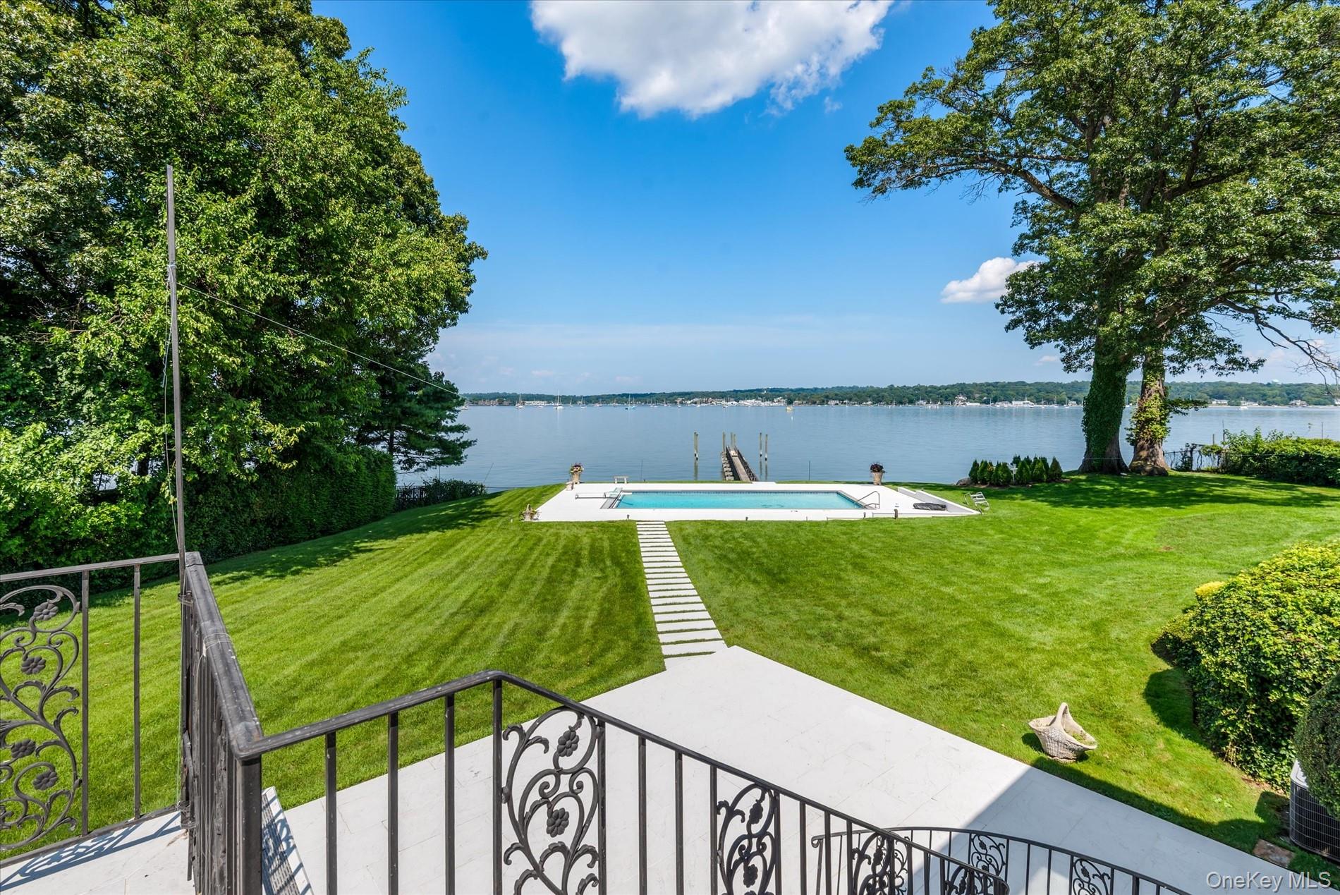 512 East Shore Road Great Neck, NY 11024 - Photo 35 of 46 a view of a swimming pool with a garden and trees