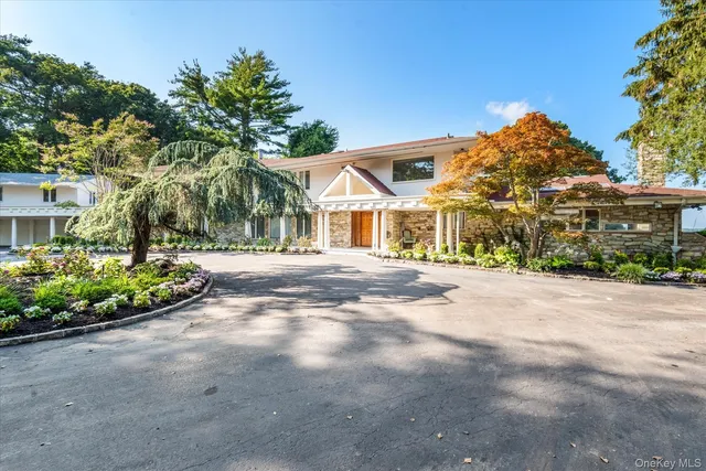 a front view of a house with a yard and outdoor seating