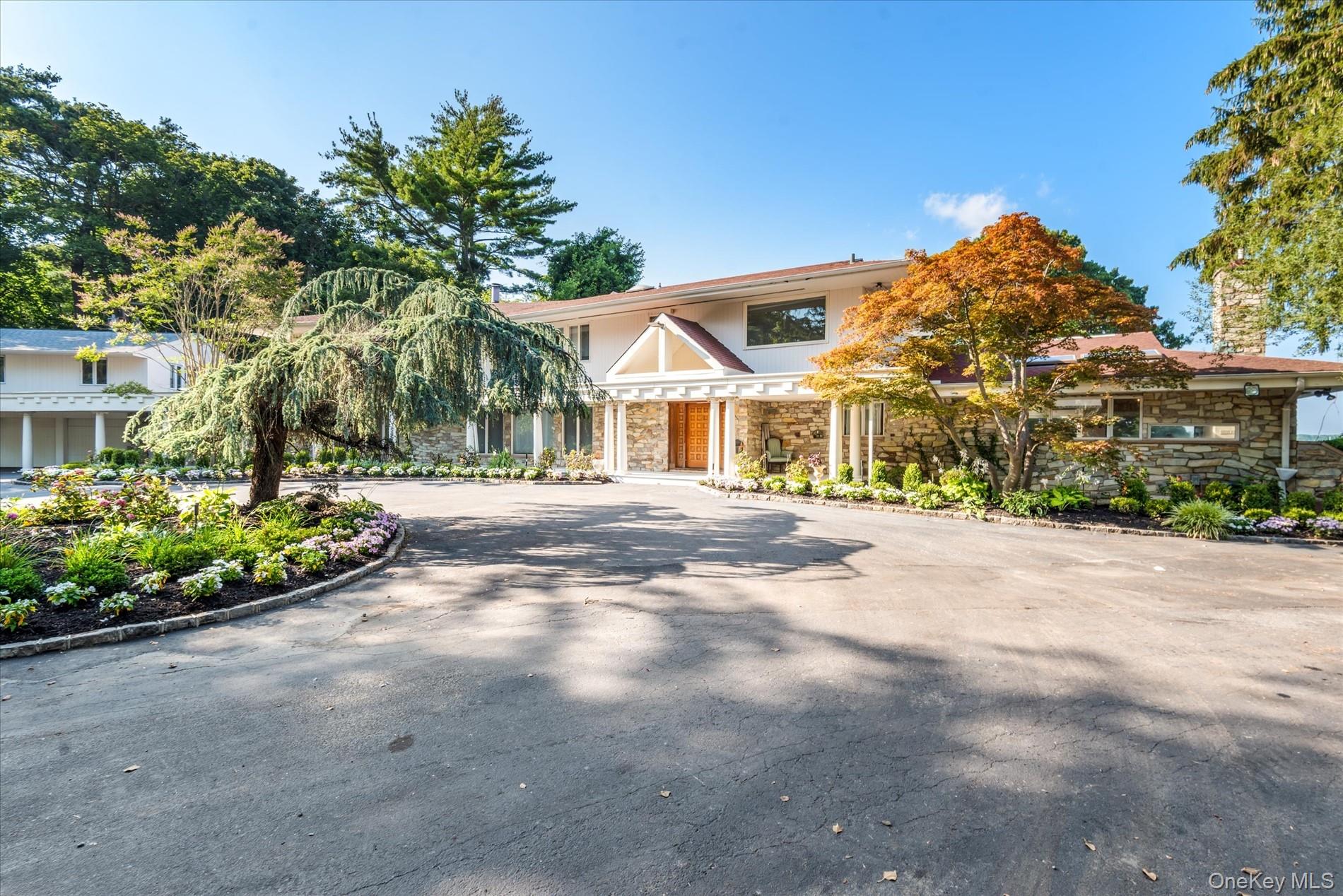 512 East Shore Road Great Neck, NY 11024 - Photo 6 of 46 a front view of a house with a yard and outdoor seating