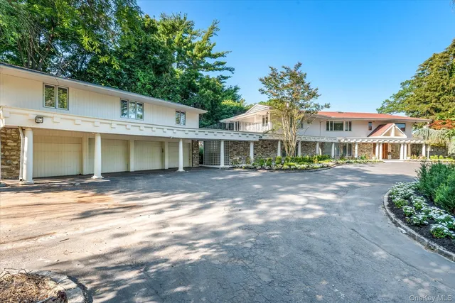 a view of a white house with a large windows and a large tree