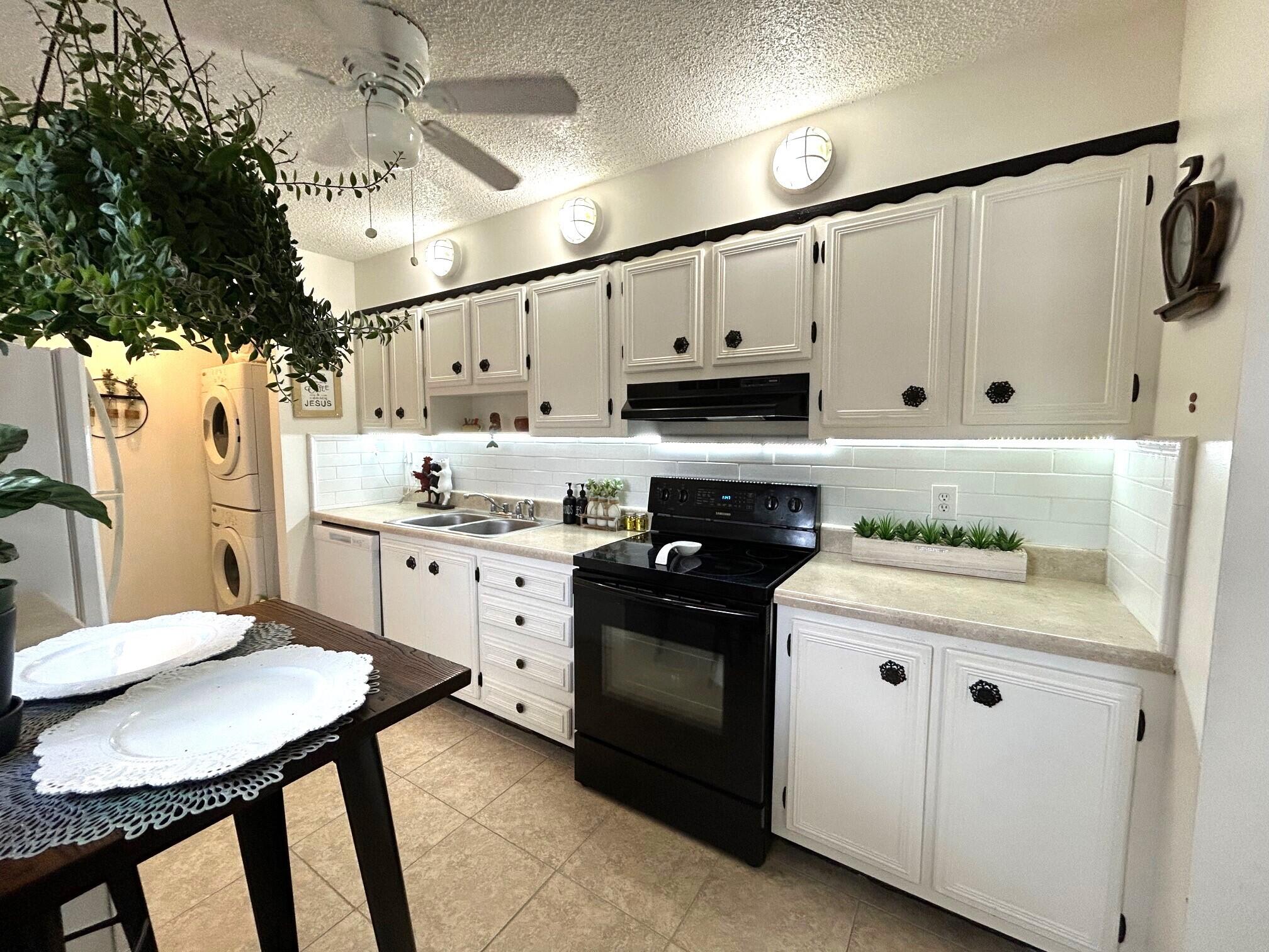 255 Down E Lane, Unit B Lake Worth, FL 33467 - Photo 5 of 31 a kitchen with white cabinets and appliances
