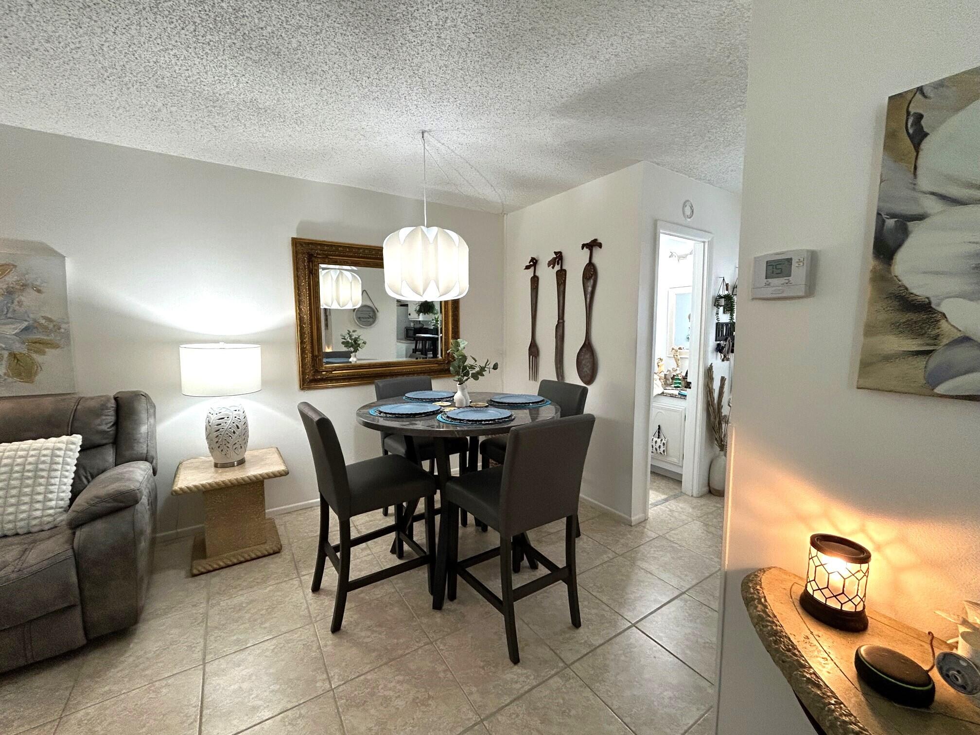 255 Down E Lane, Unit B Lake Worth, FL 33467 - Photo 10 of 31 a view of a dining room with furniture and a chandelier