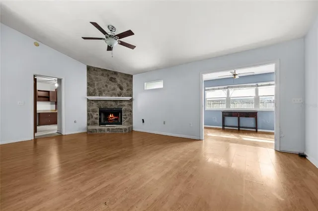 a view of an empty room with window and wooden floor