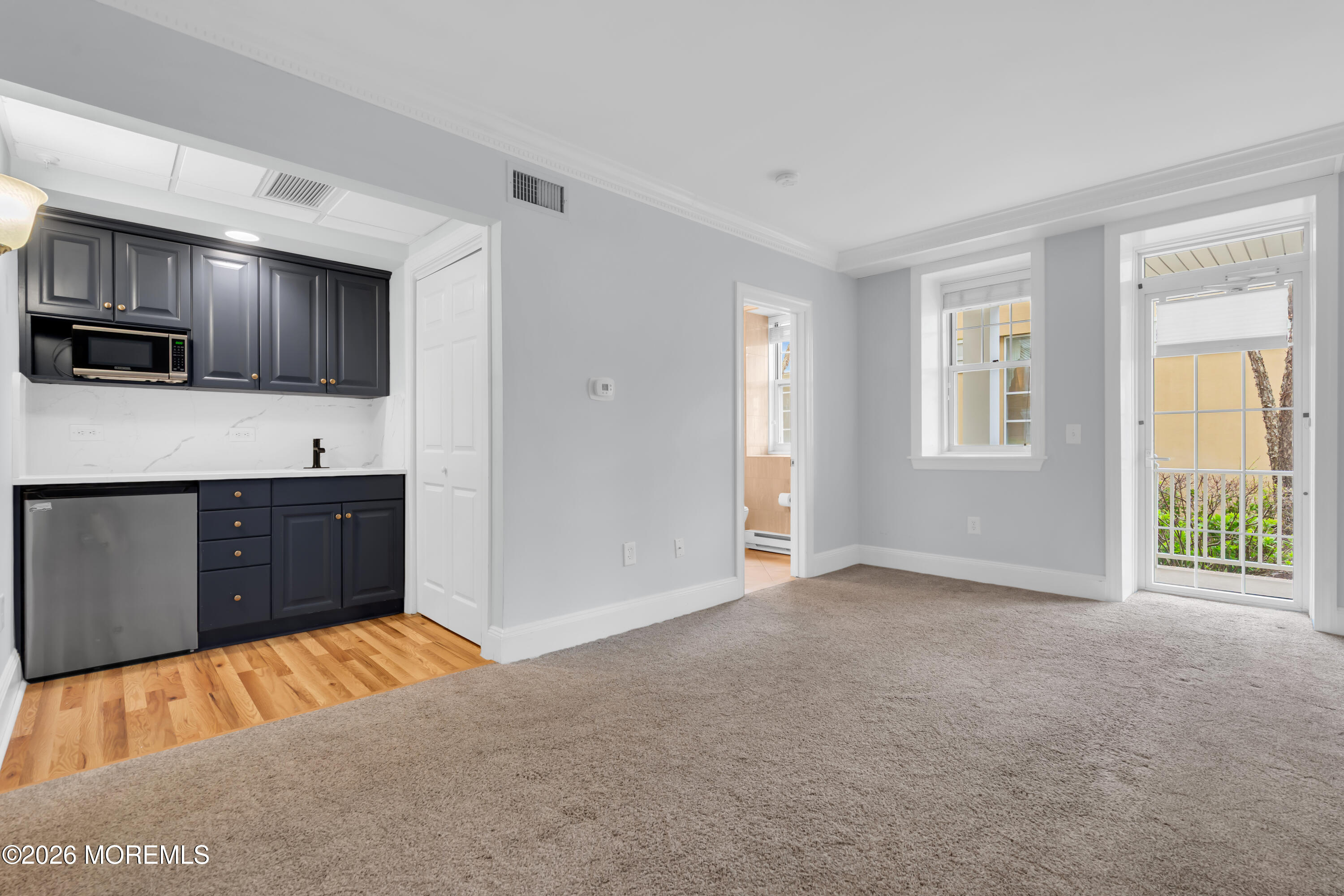 700 Ocean Avenue, Unit G29 Spring Lake, NJ 07762 - Photo 18 of 25 a living room with a couch and a flat screen tv