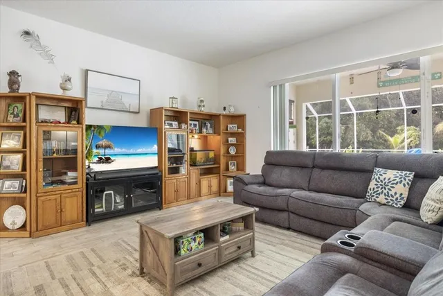 a living room with furniture a large window and stainless steel appliances