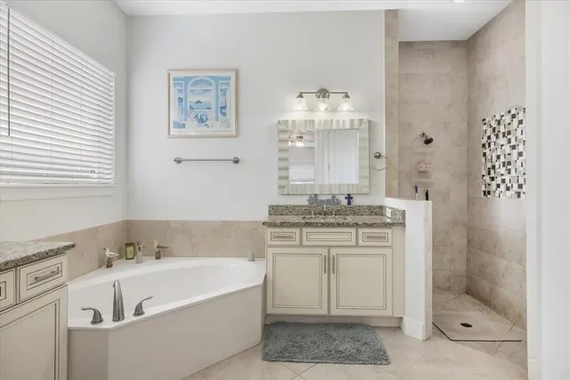 a bathroom with a tub sink and mirror