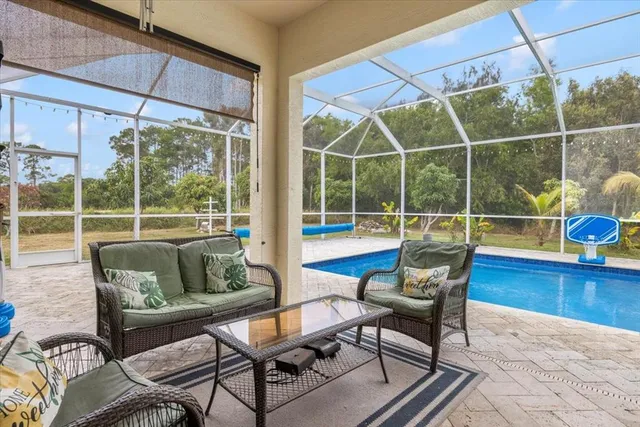 a living room with furniture and a floor to ceiling window