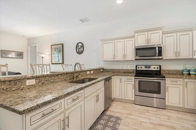 a kitchen with granite countertop a sink stove and cabinets