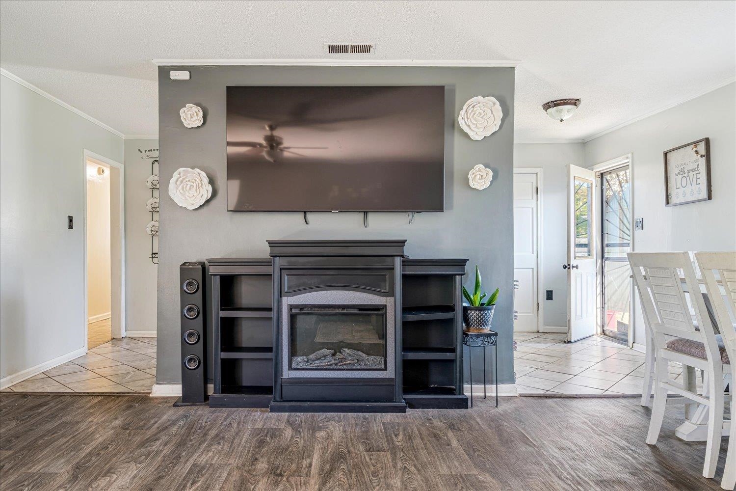 4340 Bluebell Street Memphis, TN 38109 - Photo 12 of 29 Living room with ornamental molding, a glass covered fireplace, wood finished floors, and a textured ceiling