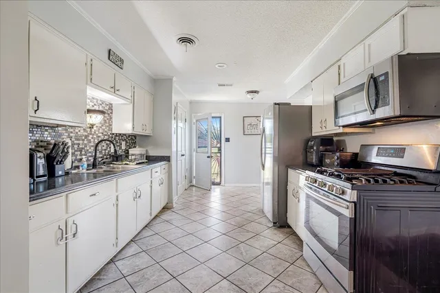 a kitchen with stainless steel appliances granite countertop a stove a sink and a refrigerator