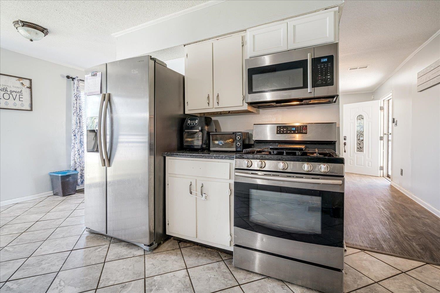 4340 Bluebell Street Memphis, TN 38109 - Photo 15 of 29 a kitchen with stainless steel appliances granite countertop a stove a microwave and a refrigerator