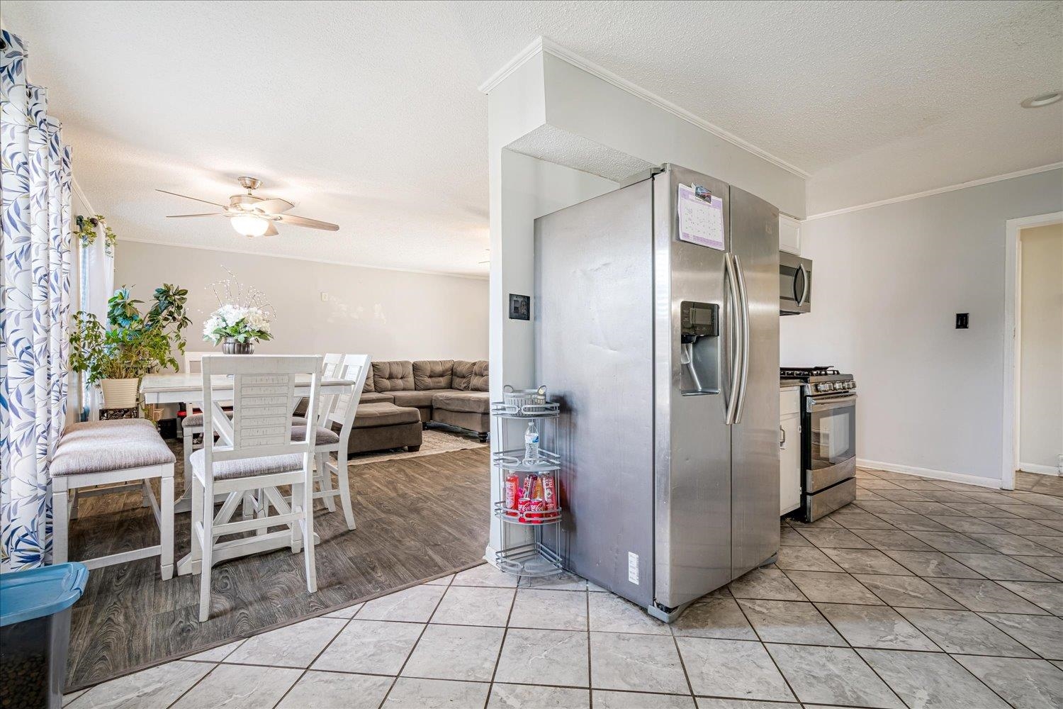 4340 Bluebell Street Memphis, TN 38109 - Photo 16 of 29 Kitchen with appliances with stainless steel finishes, light tile patterned flooring, ceiling fan, a textured ceiling, and ornamental molding