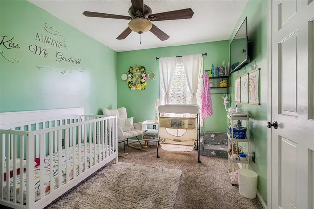 a bedroom with a large bed and a chandelier