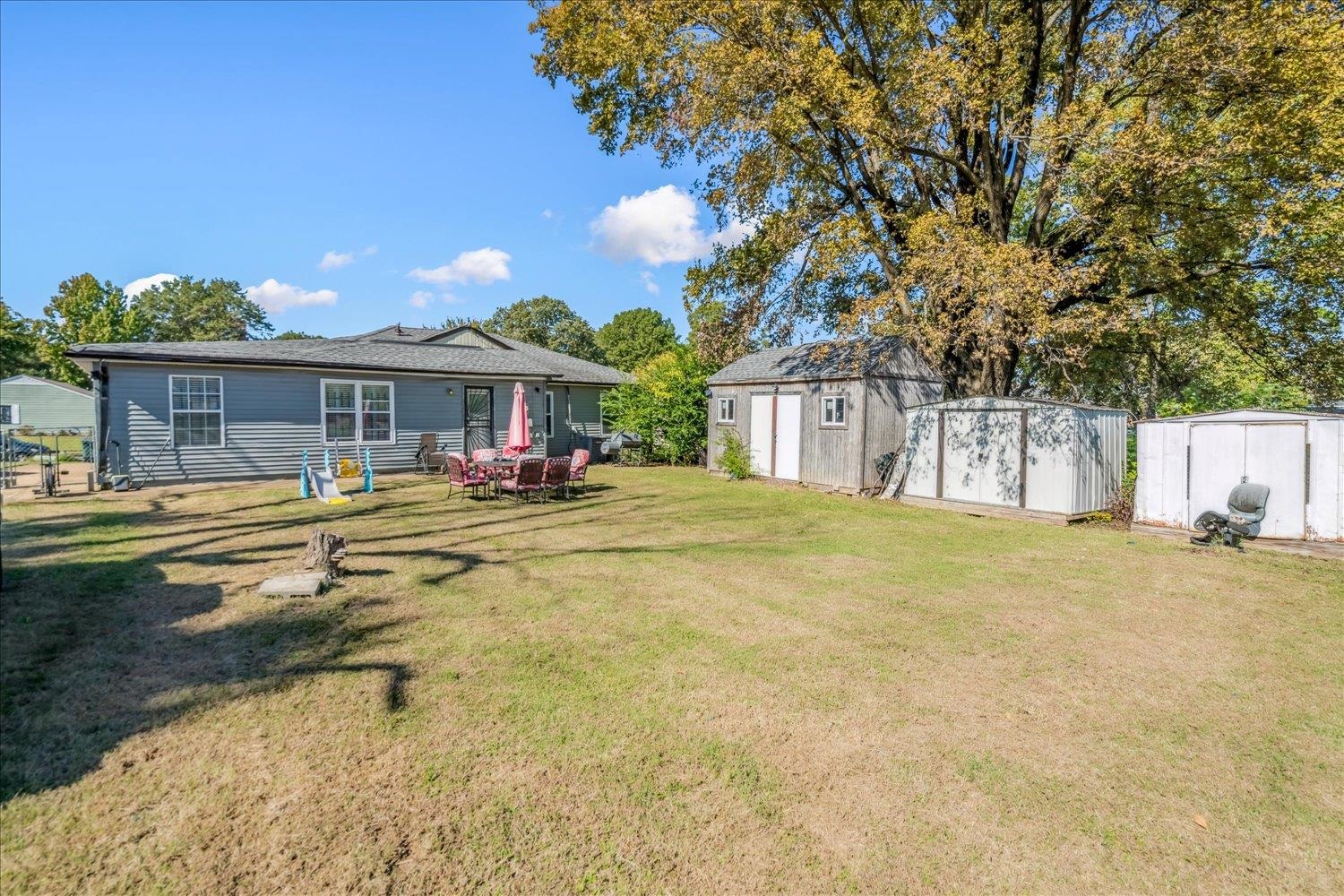 4340 Bluebell Street Memphis, TN 38109 - Photo 24 of 29 View of green lawn featuring a storage unit and a patio