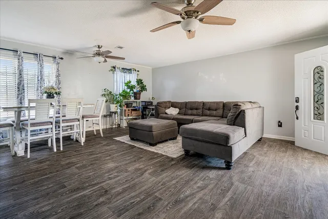 a living room with furniture and a wooden floor