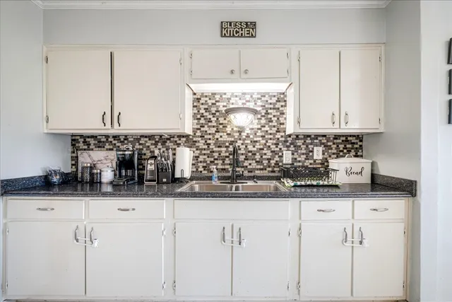 a kitchen with granite countertop a sink and cabinets