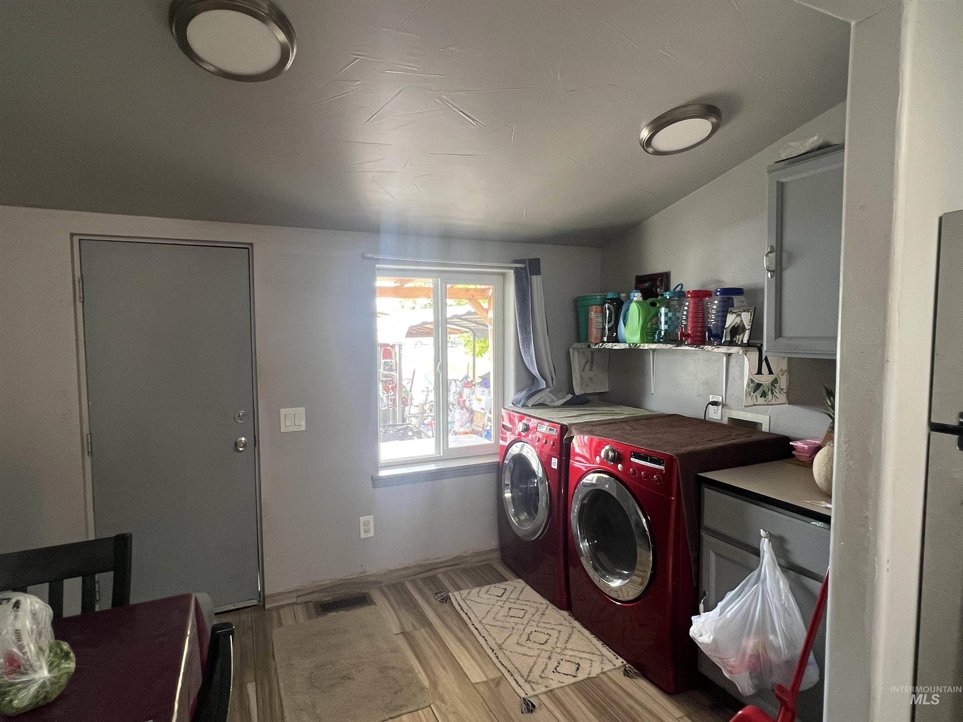 121 North 1st Street Nyssa, OR 97913 - Photo 10 of 20 Utility area featuring wood-finish flooring, two flush-mount ceiling lights, and a window providing natural illumination