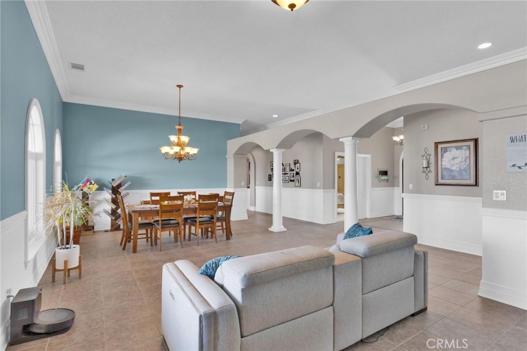 12290 Larch Road Oak Hills, CA 92344 - Photo 13 of 75 a living room with furniture a dining table and a chandelier