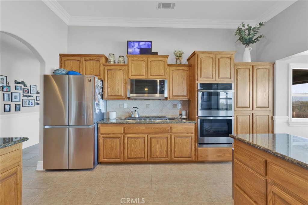12290 Larch Road Oak Hills, CA 92344 - Photo 25 of 75 a kitchen with stainless steel appliances granite countertop a refrigerator a stove and a sink