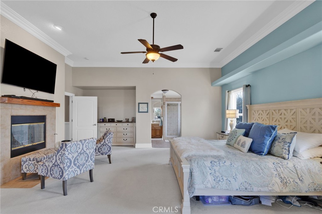 12290 Larch Road Oak Hills, CA 92344 - Photo 33 of 75 a bedroom with a bed a flat screen tv and a fireplace