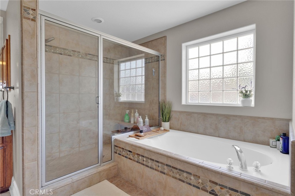 12290 Larch Road Oak Hills, CA 92344 - Photo 37 of 75 a bathroom with a tub a sink and a window
