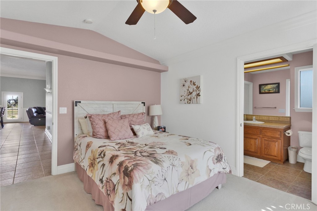 12290 Larch Road Oak Hills, CA 92344 - Photo 40 of 75 a bedroom with a bed and a chandelier