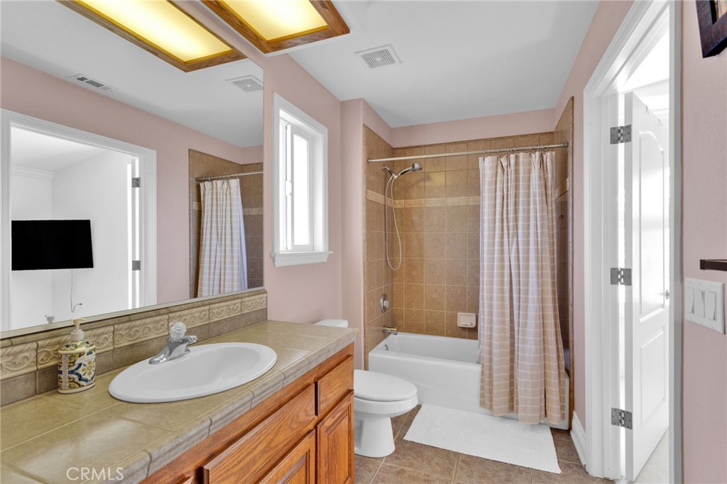 12290 Larch Road Oak Hills, CA 92344 - Photo 41 of 75 a bathroom with a granite countertop sink a toilet a mirror and shower