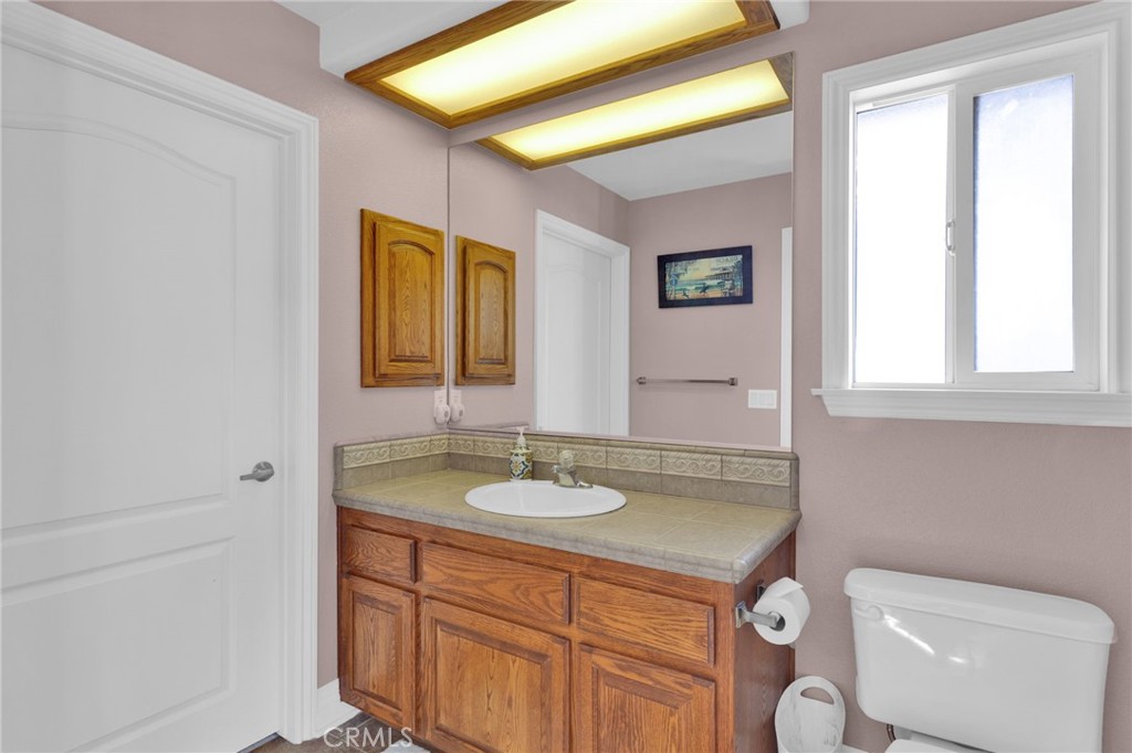 12290 Larch Road Oak Hills, CA 92344 - Photo 42 of 75 a bathroom with a granite countertop sink mirror and toilet