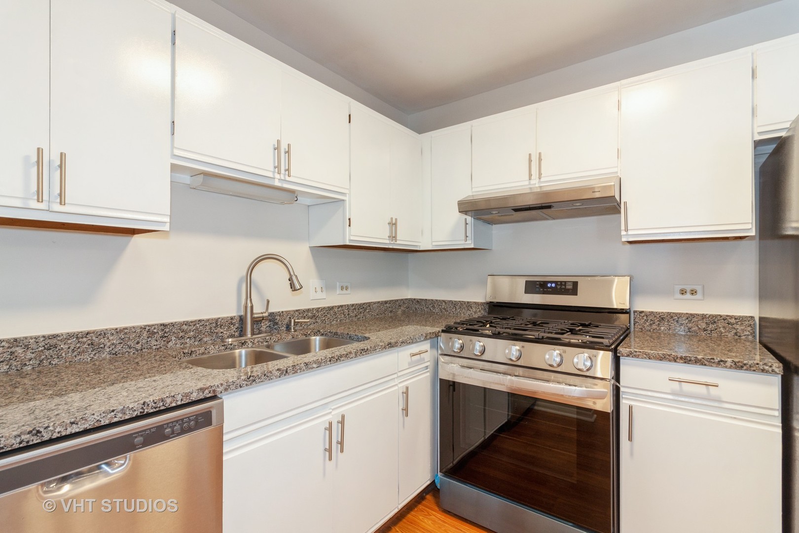 1352 McDowell Road, Unit 103 Naperville, IL 60563 - Photo 3 of 12 a kitchen with granite countertop a stove sink and cabinets
