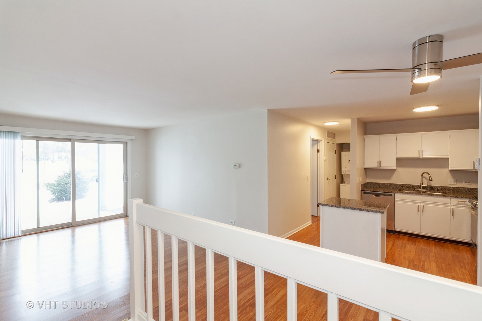 1352 McDowell Road, Unit 103 Naperville, IL 60563 - Photo 6 of 12 a kitchen with a stove a refrigerator and white cabinets with wooden floor