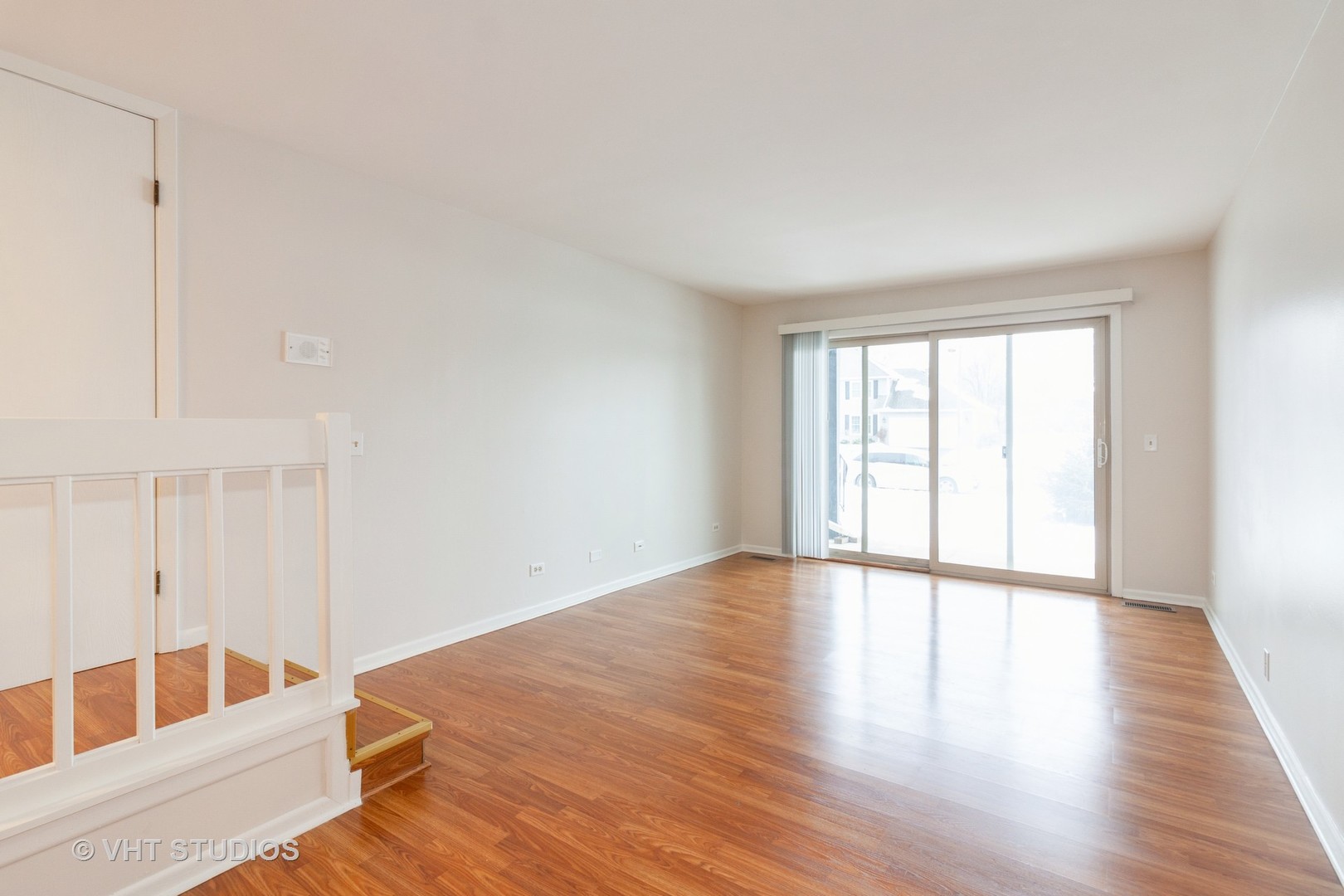 1352 McDowell Road, Unit 103 Naperville, IL 60563 - Photo 7 of 12 a view of an empty room with wooden floor and a window