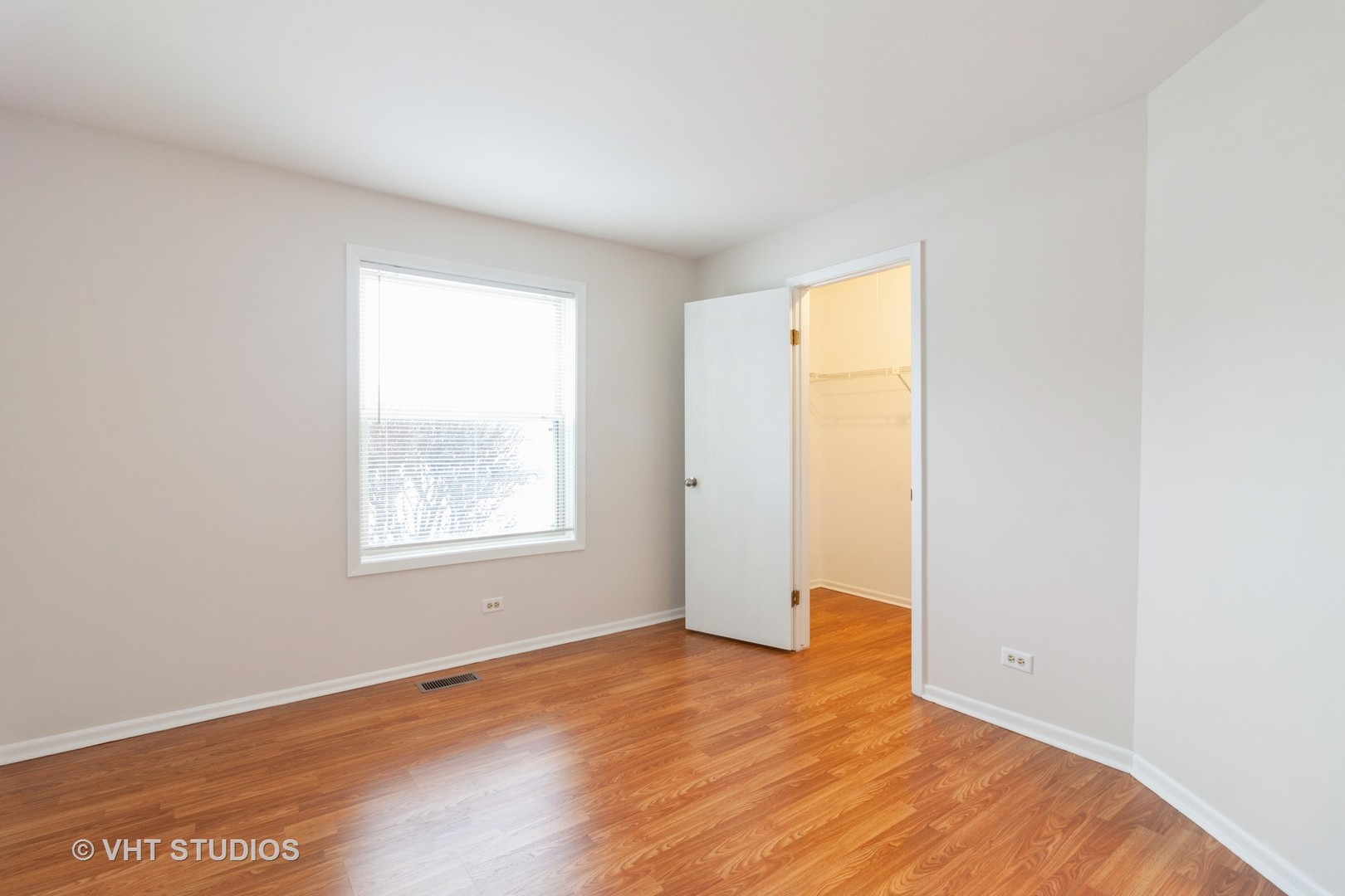 1352 McDowell Road, Unit 103 Naperville, IL 60563 - Photo 9 of 12 an empty room with wooden floor and windows