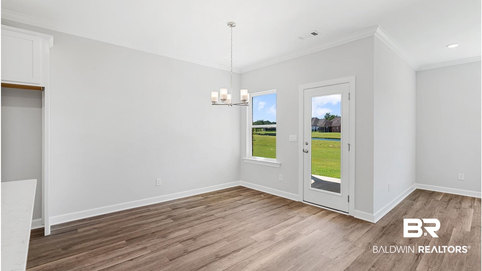 30567 Asheville Road Daphne, AL 36527 - Photo 6 of 29 Unfurnished dining area with ornamental molding, light wood-type flooring, and a chandelier