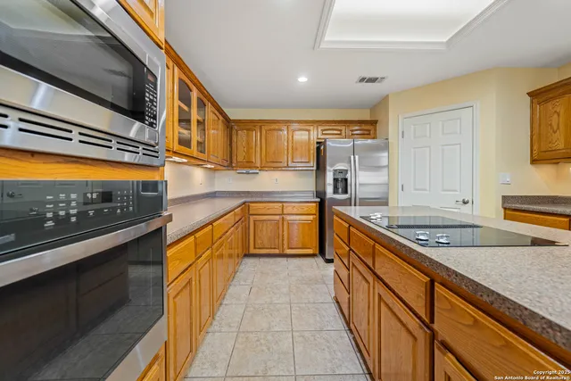 a view of an empty room with wooden floor fireplace and a window