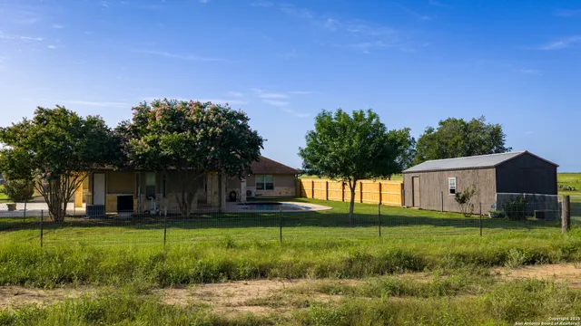 a view of a house with swimming pool and a yard