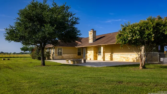 an empty room with kitchen and chandelier fan