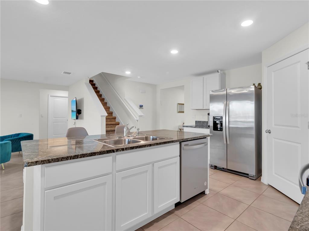 5446 Logan Cave Avenue Wimauma, FL 33598 - Photo 14 of 57 a kitchen with stainless steel appliances granite countertop a sink a stove and a refrigerator