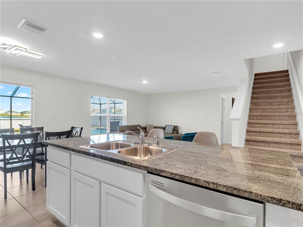 5446 Logan Cave Avenue Wimauma, FL 33598 - Photo 15 of 57 a kitchen with granite countertop sink and cabinets