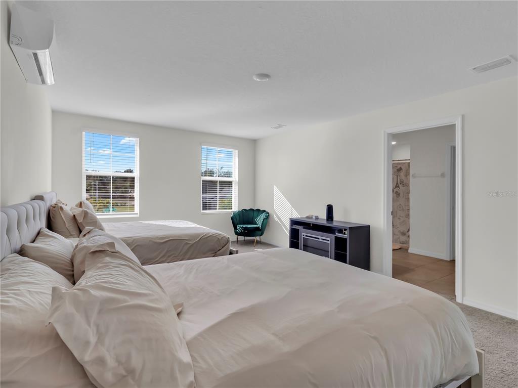 5446 Logan Cave Avenue Wimauma, FL 33598 - Photo 32 of 57 a bedroom with a large bed and a window