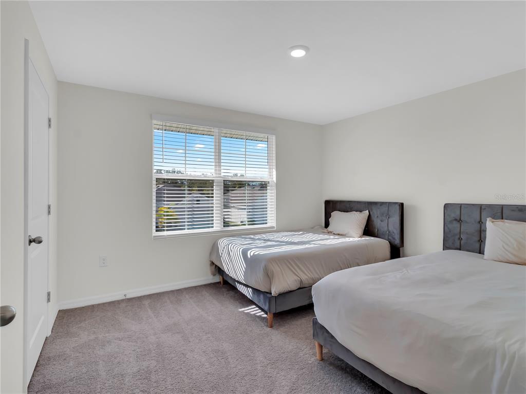 5446 Logan Cave Avenue Wimauma, FL 33598 - Photo 42 of 57 a spacious bedroom with two beds and a window