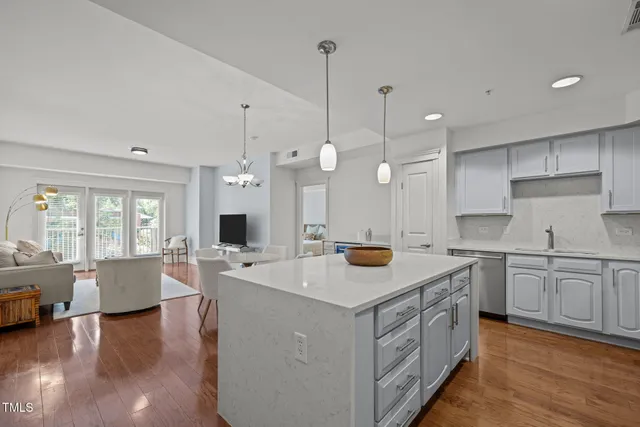 a kitchen that has a lot of cabinets a sink a stove and wooden floor